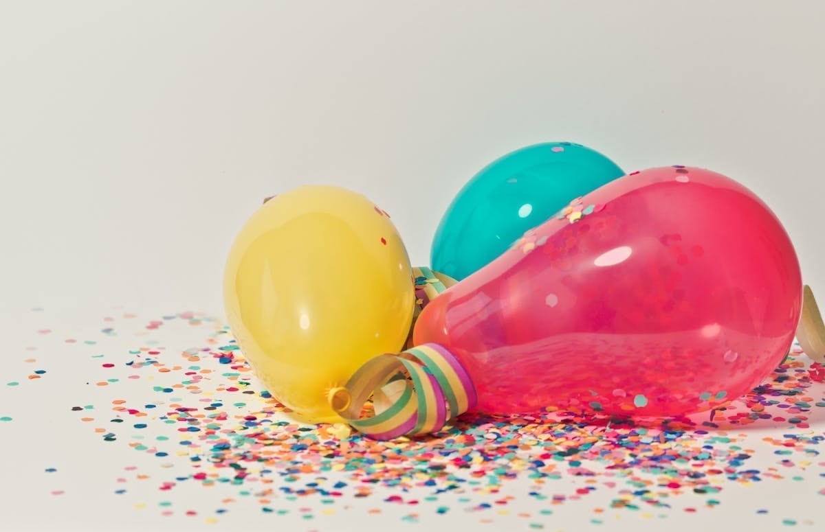 Colorful balloons surrounded by confetti for a party celebration
